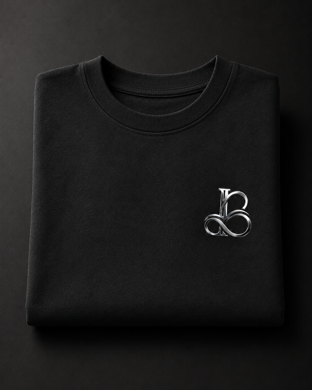 Folded black sweatshirt with a silver logo on a dark background