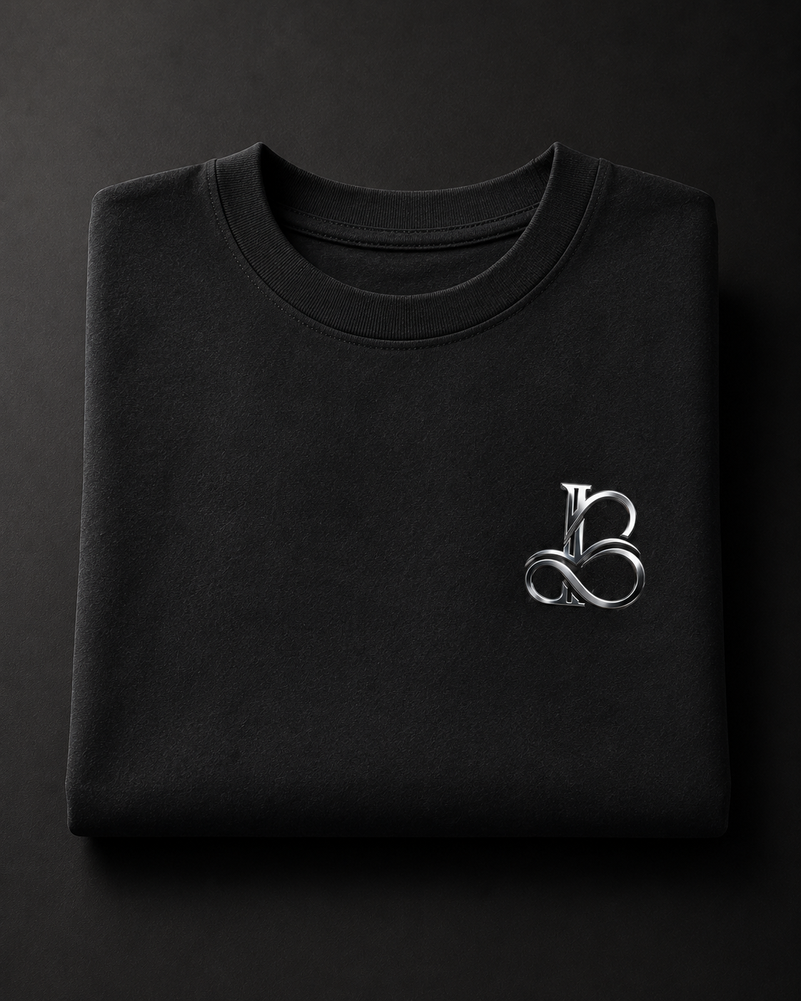 Folded black sweatshirt with a silver logo on a dark background