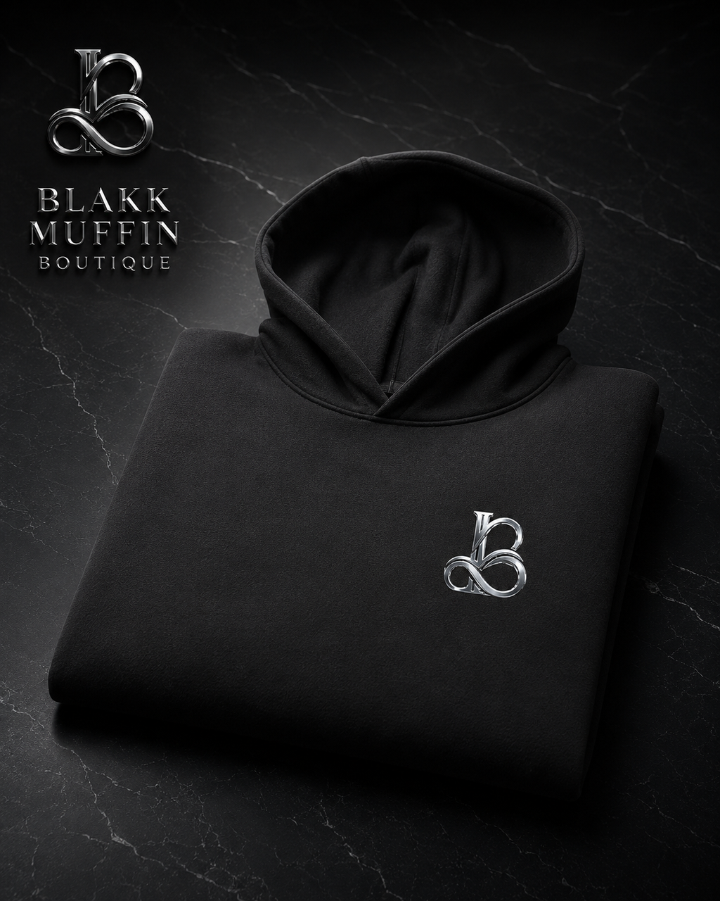 Black hoodie with a logo on a dark background, featuring Blakk Muffin Boutique branding.