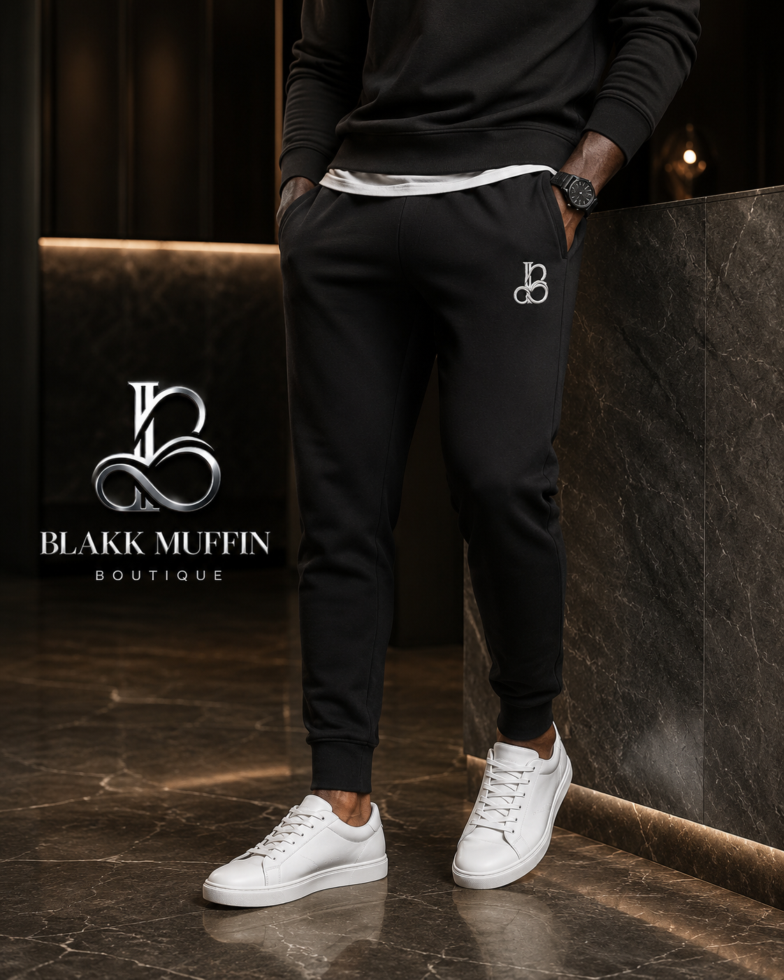 Person wearing black jogger pants and white sneakers with Blakk Muffin Boutique logo in the background.