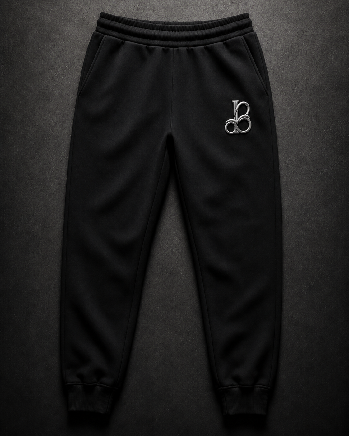 Black sweatpants with a logo on a dark gray background